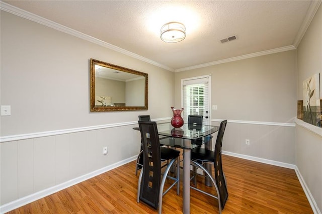 3645 Shrewsbury Ct, Snellville, GA 30039 - dining area featuring wood finished floors, ornamental molding, wainscoting, and a textured ceiling