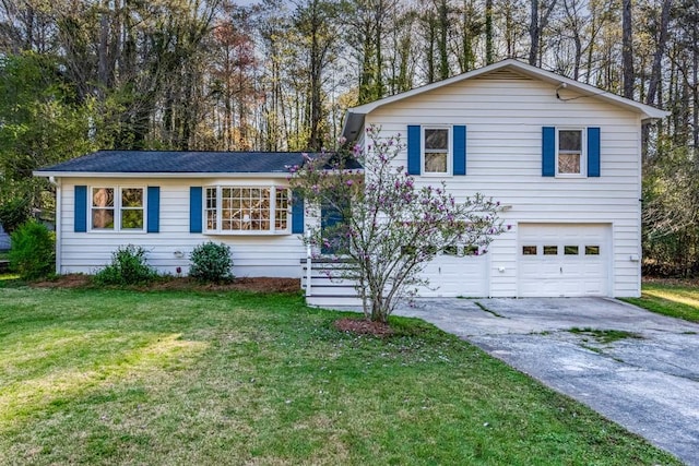 tri-level home featuring a front lawn, driveway, and a garage