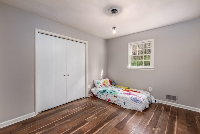 unfurnished bedroom featuring a closet and dark wood-type flooring