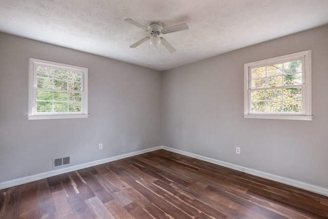 spare room with a textured ceiling, ceiling fan, and dark hardwood / wood-style floors