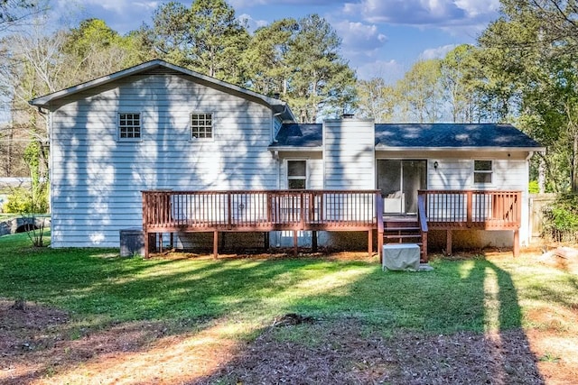 back of house with a wooden deck, a yard, and a chimney