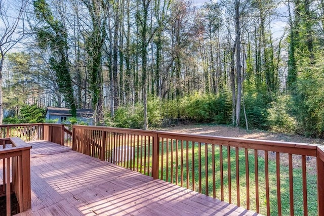 wooden terrace featuring a lawn
