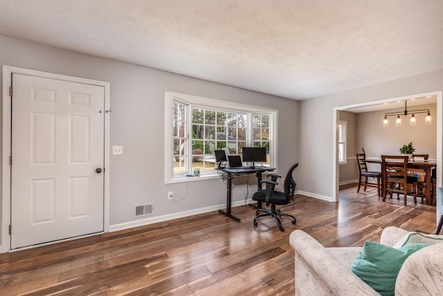 office space with a chandelier, a textured ceiling, and dark wood-type flooring