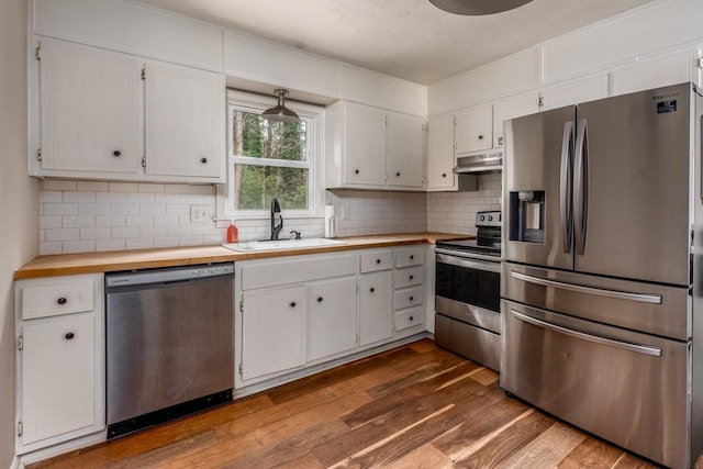 kitchen with white cabinetry, sink, dark wood-type flooring, stainless steel appliances, and butcher block countertops