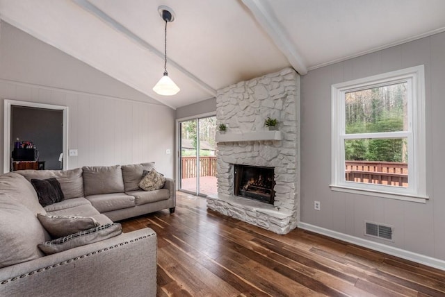 living room with dark hardwood / wood-style floors, lofted ceiling with beams, and a stone fireplace