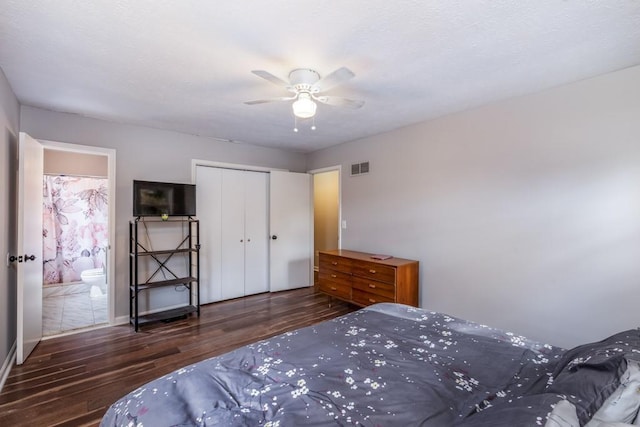 bedroom with ceiling fan, ensuite bathroom, dark wood-type flooring, and a closet