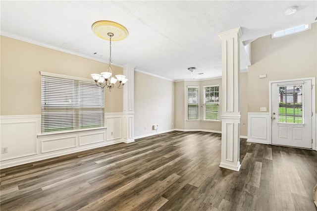 1212 Ashton Park Dr, Lawrenceville, GA 30045 - entryway featuring decorative columns, a chandelier, plenty of natural light, dark wood-style flooring, and a wainscoted wall