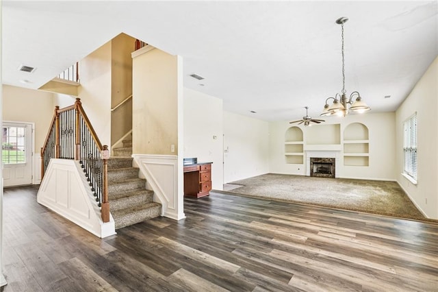 1212 Ashton Park Dr, Lawrenceville, GA 30045 - unfurnished living room with built in shelves, dark wood-type flooring, healthy amount of natural light, and a chandelier