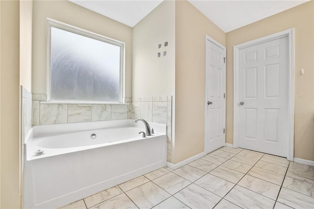 1212 Ashton Park Dr, Lawrenceville, GA 30045 - bathroom with a garden tub, baseboards, and marble finish flooring