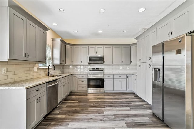 1212 Ashton Park Dr, Lawrenceville, GA 30045 - kitchen featuring appliances with stainless steel finishes, a sink, dark wood-style floors, light stone counters, and recessed lighting