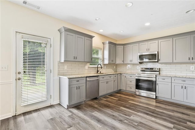 1212 Ashton Park Dr, Lawrenceville, GA 30045 - kitchen with stainless steel appliances, gray cabinets, a sink, dark wood-style floors, and healthy amount of natural light