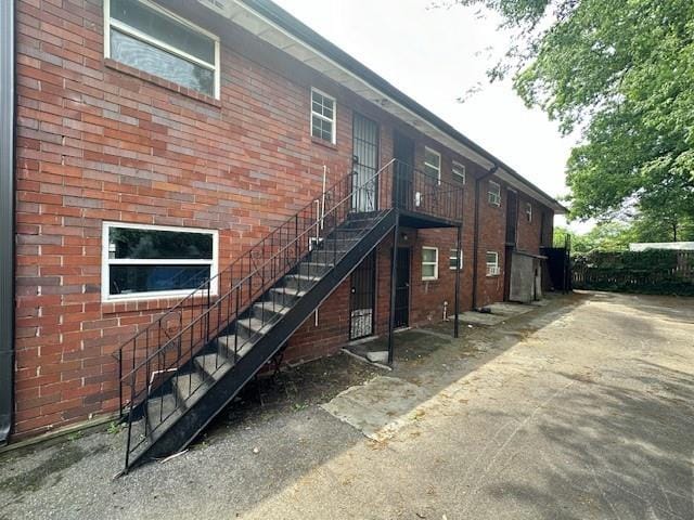 back of house with stairway and brick siding