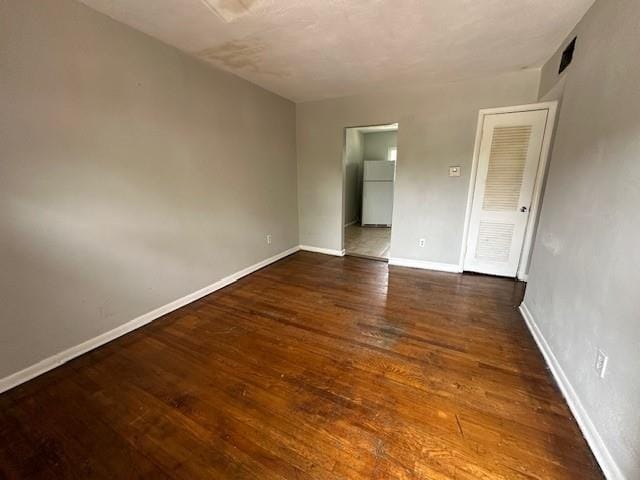 empty room with baseboards and wood finished floors
