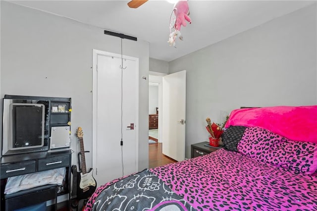 bedroom with ceiling fan, hardwood / wood-style floors, and a closet