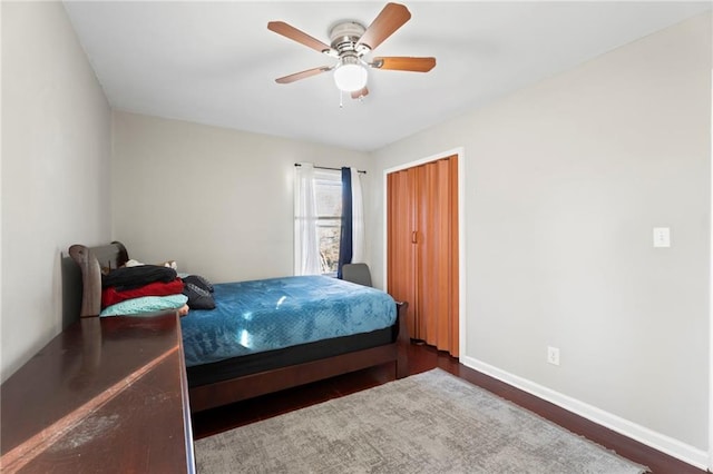 bedroom with a ceiling fan, baseboards, and wood finished floors