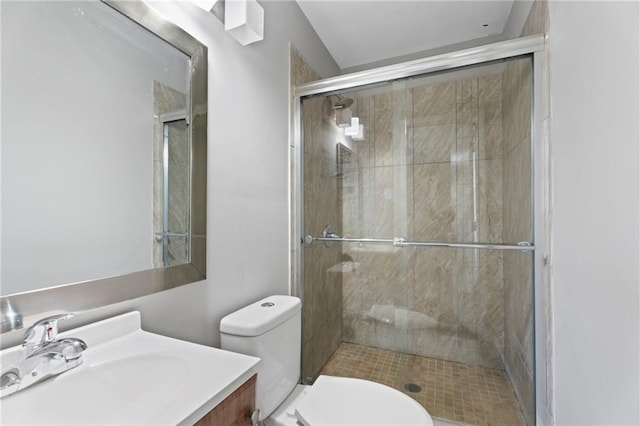 bathroom with vanity, a shower with shower door, and toilet