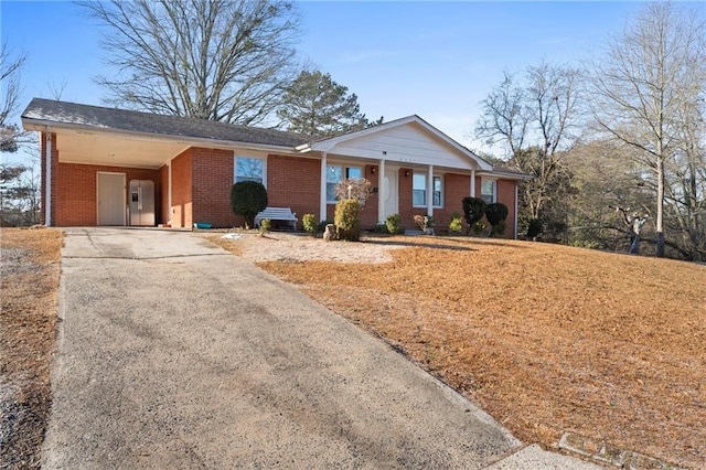 single story home featuring a carport, concrete driveway, and brick siding