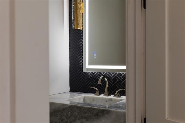 bathroom featuring a sink and backsplash