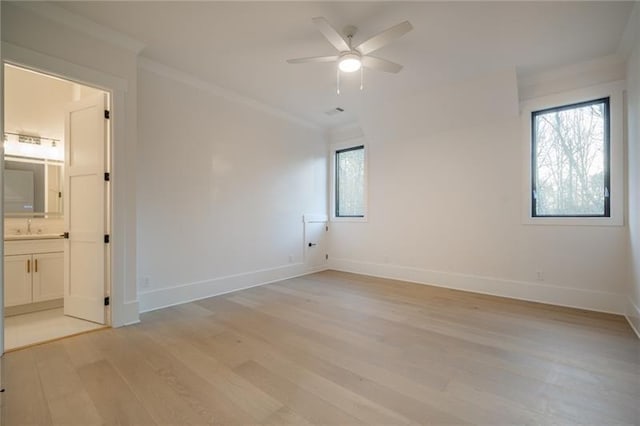 unfurnished room featuring light wood-style floors, baseboards, crown molding, and a ceiling fan