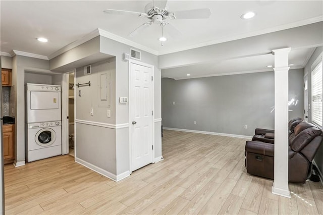 kitchen with light hardwood / wood-style flooring, ornamental molding, stacked washer and clothes dryer, and ornate columns