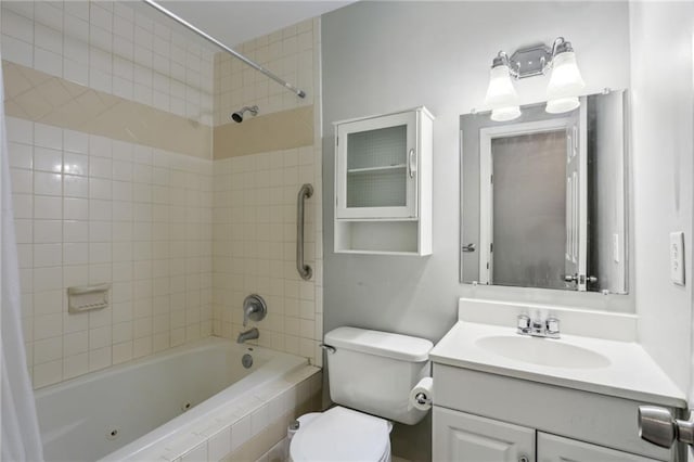 full bathroom featuring vanity, tiled shower / bath combo, and toilet