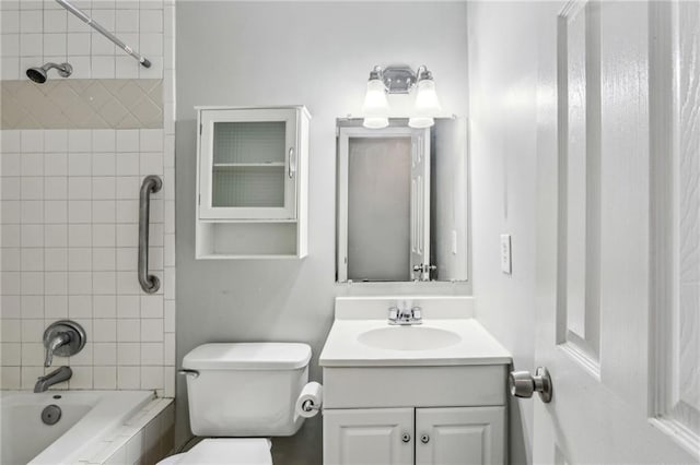 full bathroom featuring tiled shower / bath combo, vanity, and toilet