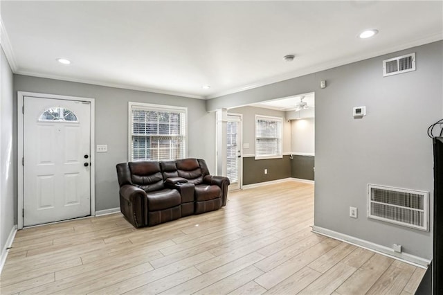 living room with decorative columns, ornamental molding, ceiling fan, and light hardwood / wood-style floors