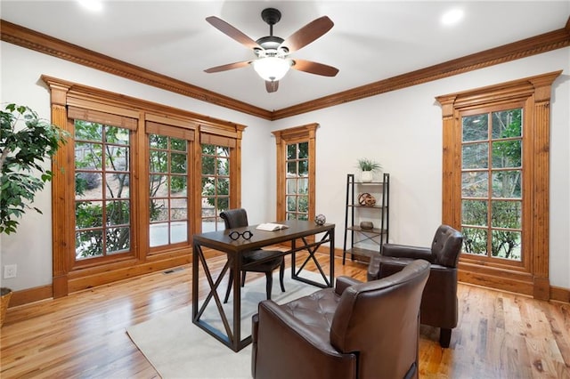 office area with a ceiling fan, light wood-type flooring, baseboards, and ornamental molding