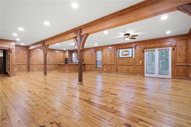unfurnished living room with wood walls, a ceiling fan, light wood-style floors, crown molding, and recessed lighting