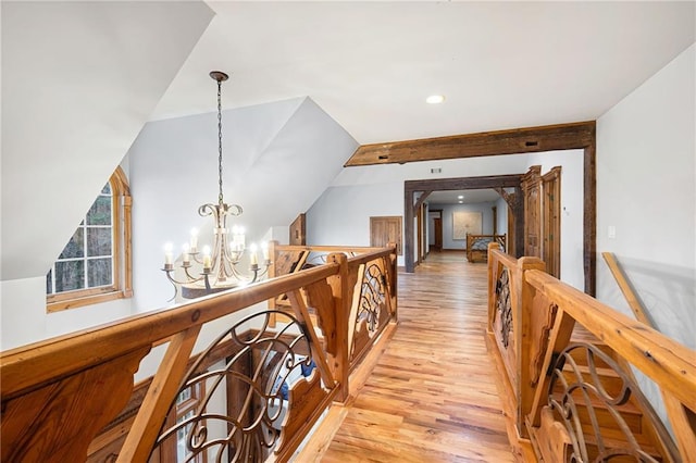 hallway with an upstairs landing, a chandelier, light wood-style flooring, and recessed lighting