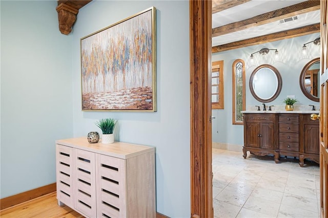 corridor featuring baseboards and a sink