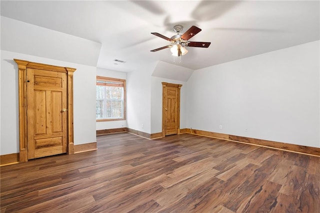 bonus room featuring baseboards, dark wood-style flooring, ceiling fan, and vaulted ceiling