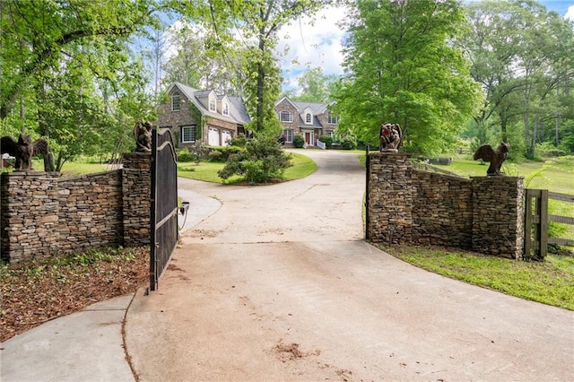 view of concrete driveway featuring a gated entry