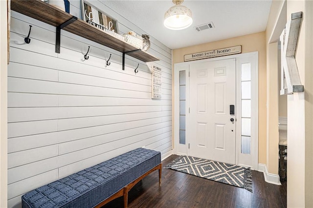 mudroom featuring dark hardwood / wood-style floors and wooden walls