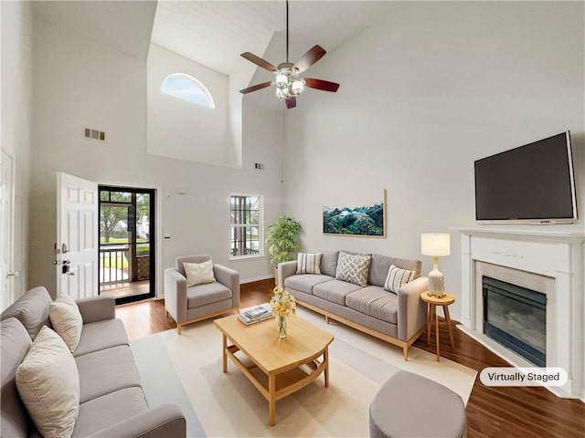 living room featuring ceiling fan, light hardwood / wood-style floors, and high vaulted ceiling