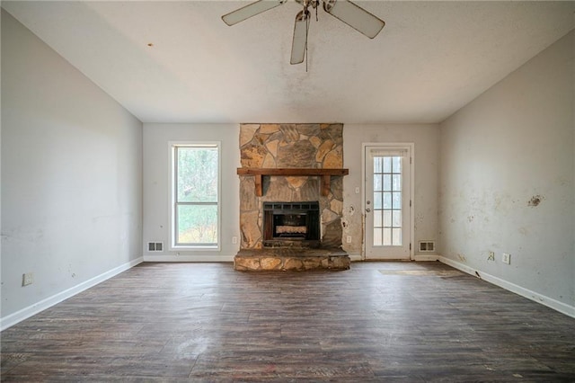 unfurnished living room featuring dark wood-style floors, baseboards, a fireplace, and visible vents