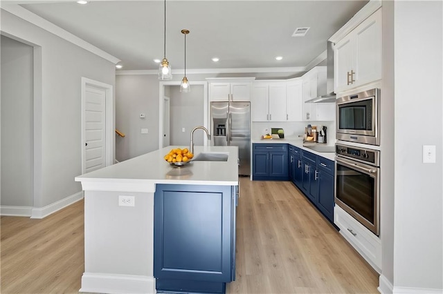 kitchen featuring pendant lighting, blue cabinetry, stainless steel appliances, an island with sink, and white cabinets