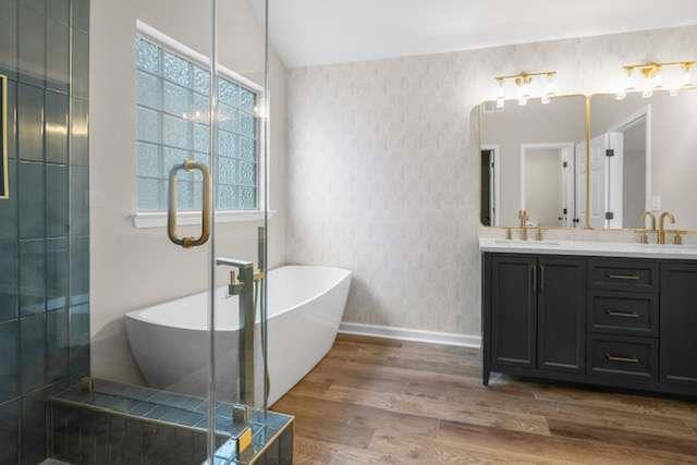 bathroom with vanity, vaulted ceiling, shower with separate bathtub, and hardwood / wood-style floors