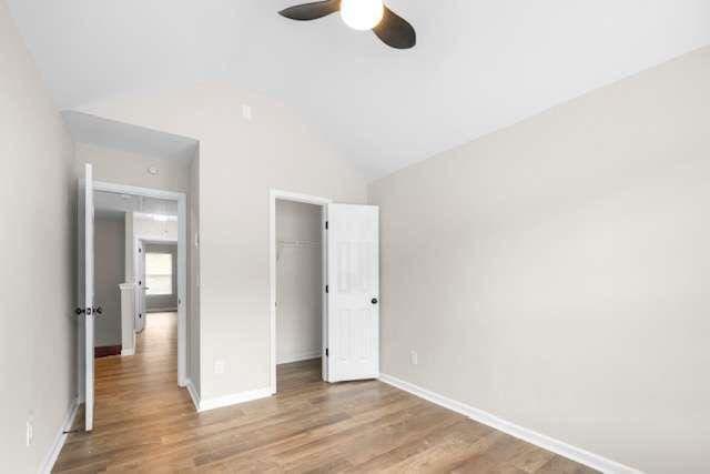 unfurnished bedroom with ceiling fan, a closet, lofted ceiling, and light hardwood / wood-style flooring