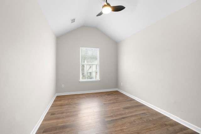 unfurnished room featuring dark wood-type flooring, ceiling fan, and vaulted ceiling