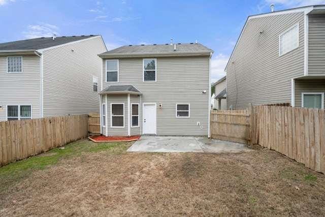 rear view of property with a yard and a patio area