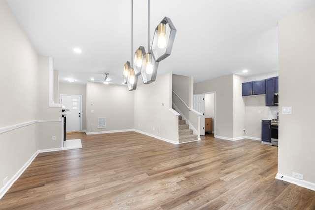 unfurnished living room with hardwood / wood-style floors and a notable chandelier