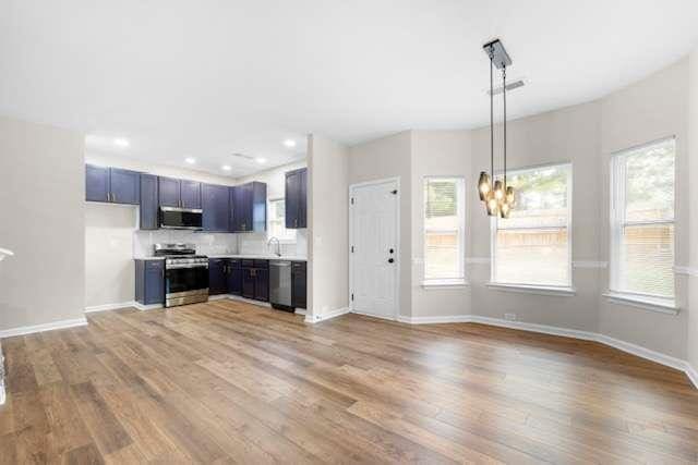 kitchen featuring an inviting chandelier, appliances with stainless steel finishes, decorative light fixtures, and light hardwood / wood-style floors