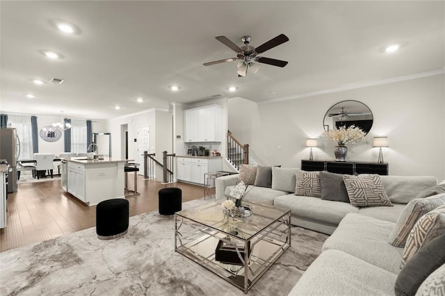 2227 Foley Park St, Snellville, GA 30078 - living area with ornamental molding, a ceiling fan, wood finished floors, recessed lighting, and stairs
