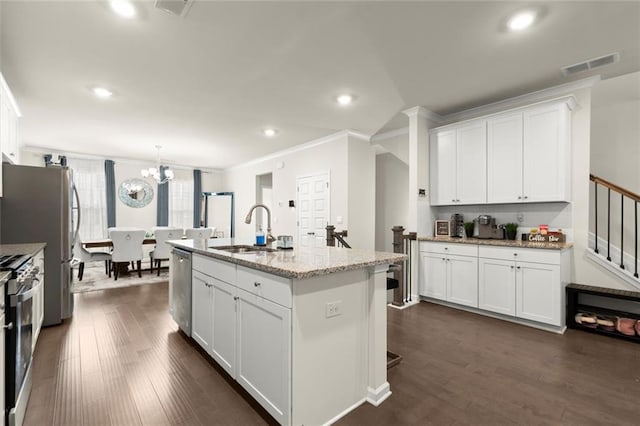 2227 Foley Park St, Snellville, GA 30078 - kitchen with crown molding, stainless steel appliances, white cabinetry, dark wood-style flooring, and light stone countertops