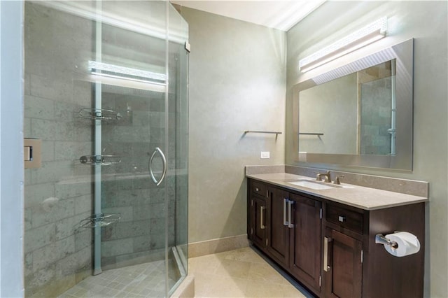bathroom featuring a shower stall, vanity, tile patterned flooring, and baseboards