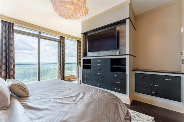 bedroom with wood finished floors, crown molding, and baseboards