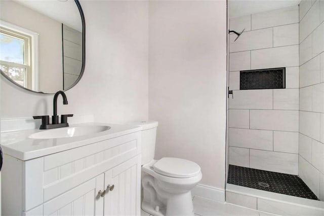 bathroom featuring vanity, toilet, and tiled shower