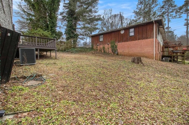 view of yard with central AC and a deck