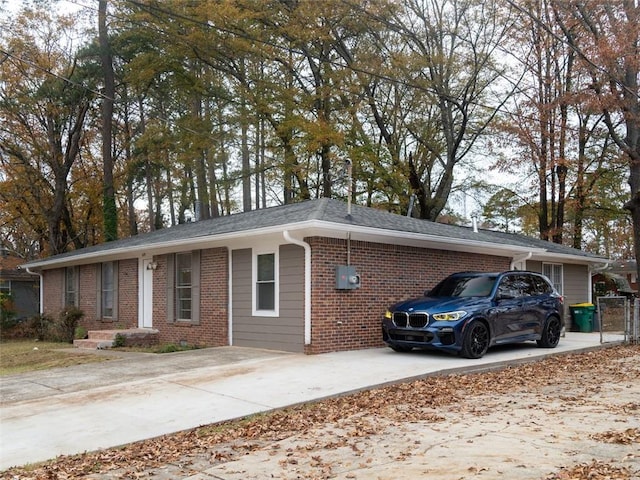 single story home featuring concrete driveway and brick siding